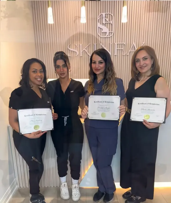 Four SKINEAV Academy graduates holding their certificates in the Vaughan clinic